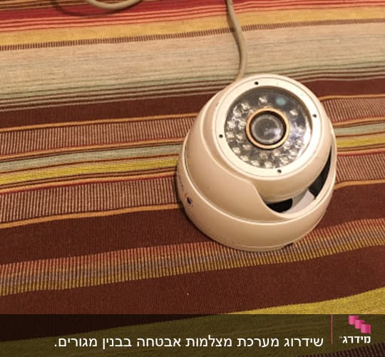 Security camera on a striped surface with cables.